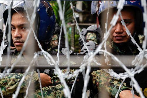 epa12539498 Philippine police keep watch from behind security barricades during an anti-corruption rally by predominantly college-level students in Manila, Philippines, 21 November 2025. President Marcos on 21 November announced that arrest warrants have been issued for a former congressman and 17 other individuals believed to be involved in anomalous...