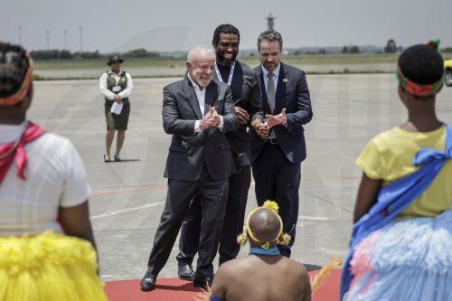 epa12539599 Brazil's President Luiz Inacio Lula da Silva (C-L) and South Africa's Higher Education Minister Buti Manamela (C) react as they watch the Umzekelo cultural group perform upon his arrival at the OR Tambo International airport in Ekurhuleni, South Africa, 21 November 2025 ahead of the G20 leader's Summit. World leaders are gathering in South...