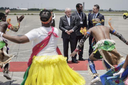 epa12539661 Brazil's President Luiz Inacio Lula da Silva (C) and South Africa's Higher Education Minister Buti Manamela (C-R) react as they watch the Umzekelo cultural group perform upon his arrival at the OR Tambo International airport in Ekurhuleni, South Africa, 21 November 2025, ahead of the G20 leader's Summit. World leaders are gathering in South...