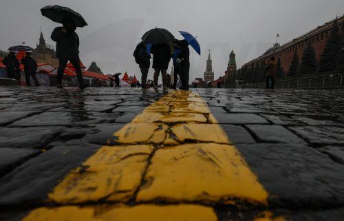epa12545515 People walk on the Red Square at a rainy autumn day in Moscow, Russia, 24 November 2025. According to weather forecasts, the next few days will be warm in Moscow, and air temperature will rise to 7 Celsius degrees.  EPA/SERGEI ILNITSKY