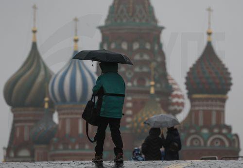 epa12545517 People with umbrellas walk on the Red Square at a rainy autumn day in Moscow, Russia, 24 November 2025. According to weather forecasts, the next few days will be warm in Moscow, and air temperature will rise to 7 Celsius degrees.  EPA/SERGEI ILNITSKY