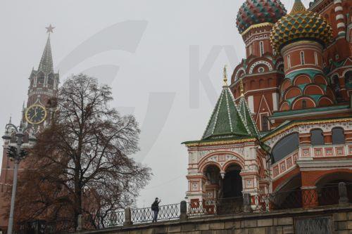 epa12545520 A man stands near the Spasskaya tower of the Kremlin and St. Basil's Cathedral covered the mist on the Red Square in Moscow, Russia, 24 November 2025. According to weather forecasts, the next few days will be warm in Moscow, and air temperature will rise to 7 Celsius degrees.  EPA/SERGEI ILNITSKY