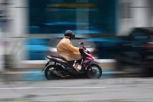 epa12549220 A motorist using a raincoat drives under heavy rain in Banda Aceh, Indonesia, 26 November 2025. The Meteorology, Climatology, and Geophysics Agency (BMKG) issued an early warning for extreme weather across the island of Sumatra, from Aceh to West Sumatra. The severe weather, including heavy rainfall with high intensity, has caused hydrological...