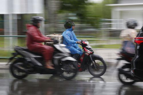 epa12549223 Motorist using raincoats drive under heavy rain in Banda Aceh, Indonesia, 26 November 2025. The Meteorology, Climatology, and Geophysics Agency (BMKG) issued an early warning for extreme weather across the island of Sumatra, from Aceh to West Sumatra. The severe weather, including heavy rainfall with high intensity, has caused hydrological...