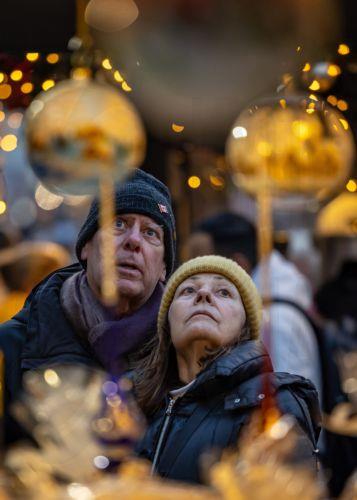 epa12562773 Visitors look at Christmas decorations at the market in Old Town Square, Prague, Czech Republic, 01 December 2025. Christmas markets, traditionally selling mulled wine, roasted chestnuts, hot mead, chimney cakes, and Christmas decorations and gifts, opened across the Czech Republic during the first Advent weekend.  EPA/MARTIN DIVISEK