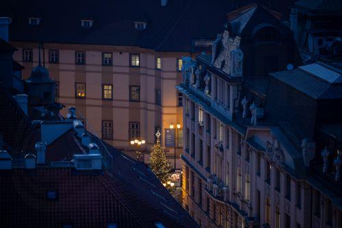 epa12562774 A Christmas tree is seen between houses in Prague, Czech Republic, 01 December 2025. Christmas markets, traditionally selling mulled wine, roasted chestnuts, hot mead, chimney cakes, and Christmas decorations and gifts, opened across the Czech Republic during the first Advent weekend.  EPA/MARTIN DIVISEK