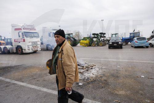 epa12566907 A person walks near tractors as farmers block the Malgara toll road as part of a nationwide farmers' mobilization in Thessaloniki, Greece, 03 December 2025. At the Malgara toll station on the Thessaloniki–Athens National Road, farmers from the Municipality of Delta and the surrounding area have been blocking the road to Athens since 01 December,...