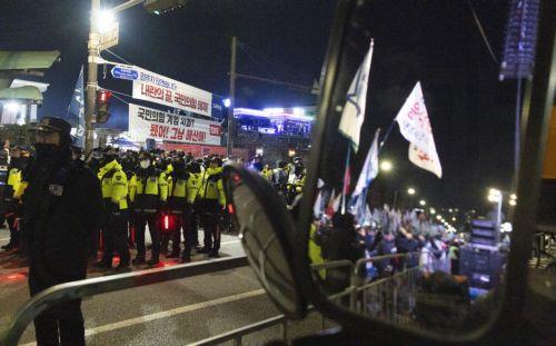 epa12566964 South Korean police officials stand guards as South Korean people participate in a demonstration to mark the first anniversary of the 03 December martial law crisis outside the National Assembly in Seoul, South Korea, 03 December 2025.  EPA/JEON HEON-KYUN