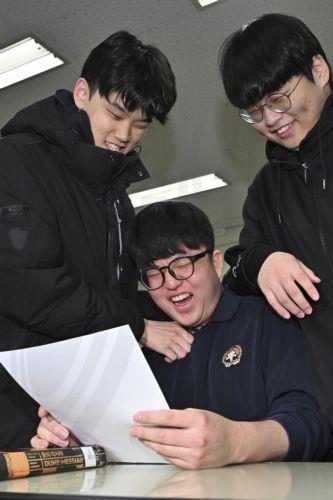 epa12571001 Wang Jung-keun (C), a senior, smiles as he is congratulated by his classmates at Gwangnam High School in Seoul, South Korea, 05 December 2025, after receiving a sheet showing he earned a perfect score on the state-administered scholastic aptitude test for the 2026 academic year that took place on 13 November. A high score on the test boosts a...