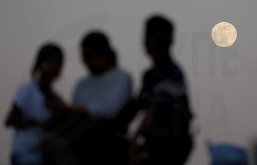 epaselect epa12569574 A family watches the supermoon in Yangon, Myanmar, 04 December 2025. This is the last Supermoon of 2025, known as the Cold Moon.  EPA/NYEIN CHAN NAING