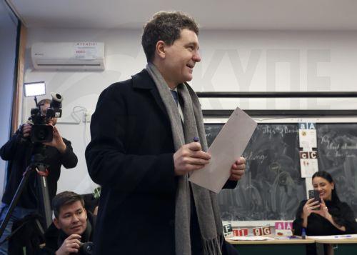 epa12576435 Romanian President Nicusor Dan (C) holds his ballot as he votes in the capital's mayoral elections at a polling station in Bucharest, Romania, 07 December 2025. The Romanian capital, Bucharest, holds its early mayoral elections on 07 December, following Nicusor Dan's ascent from mayor to President of Romania earlier this year.  EPA/ROBERT GHEMENT