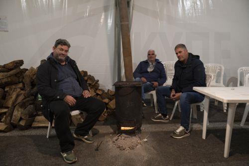 Αγρότες, που συμμετέχουν στο μπλόκο στον κόμβο της Νίκαιας στο πλαίσιο των αγροτικών κινητοποιήσεων στη Λάρισα, κάθονται γύρω από μία σόμπα να ζεσταθούν, Τρίτη 9 Δεκεμβρίου 2025. Δυναμικά συνεχίζουν και σήμερα, Τρίτη, οι αγρότες στο μπλόκο της Νίκαιας, παραμένοντας σε ετοιμότητα και διατηρώντας υψηλό τον παλμό των κινητοποιήσεων. Εκατοντάδες τρακτέρ...