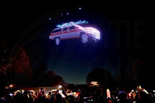 epa12582014 Crowds watch a 1987 Chevrolet Suburban created by drones during a sponsored Christmas holiday display at Piedmont Park in Atlanta, Georgia, USA, 09 December 2025. The show 'Chevy Holiday Magic', sponsored by automobile manufacturer Chevrolet, featured 1,000 choreographed drones.  EPA/ERIK S. LESSER