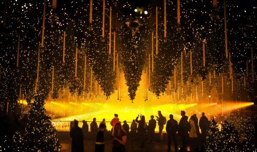 epa12585123 People visit the art installation 'Forest - Winterlights' by light and media artist Christopher Bauder at his Dark Matter art gallery in Berlin, Germany, 11 December 2025. Berlin-based light and media artist Bauder has created a poetic forest landscape covering 1,000 square metres, featuring over 600 trees, most of which float from the ceiling,...