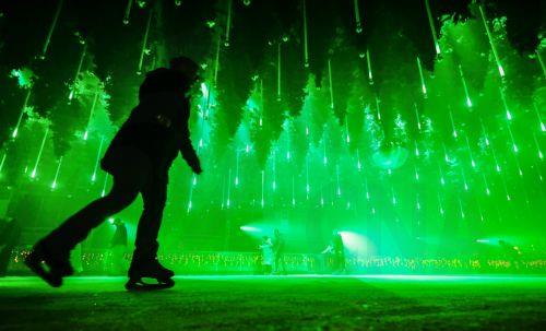 epa12585133 People skate on an ice rink in the art installation 'Forest - Winterlights 2025' by light and media artist Christopher Bauder at his Dark Matter art gallery in Berlin, Germany, 11 December 2025. Berlin-based light and media artist Bauder has created a poetic forest landscape covering 1,000 square metres, featuring over 600 trees, most of which...