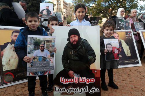 epa12587538 Activists and relatives of detainees in Israeli prisons carry pictures of the Lebanese prisoners in Israeli jails, during a protest outside the United Nations Economic and Social Commission for Western Asia (UN-ESCWA) headquarters in Beirut, Lebanon, 12 December 2025. Activists and relatives of detainees in Israeli prisons gather for a protest...