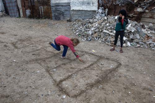 epa12594412 Displaced Palestinian children play in front of their tents on a rainy day in the city of Khan Younis, in the southern Gaza Strip, 15 December, 2025.  According to the UN around 90 percent of the population or 1.9 million people in Gaza have been displaced since the start of the conflict.  EPA/HAITHAM IMAD