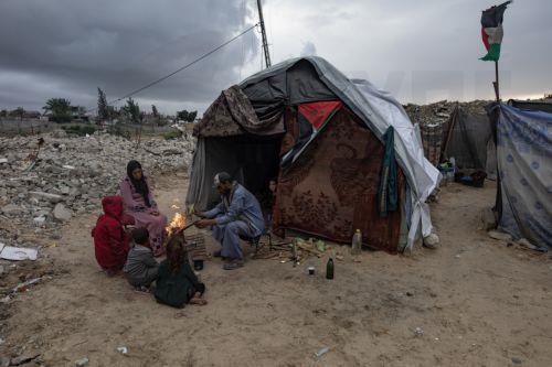 epa12594416 A displaced Palestinian family light a fire for warmth outside their shelter in the city of Khan Younis, in the southern Gaza Strip, 15 December, 2025.  According to the UN around 90 percent of the population or 1.9 million people in Gaza have been displaced since the start of the conflict.  EPA/HAITHAM IMAD