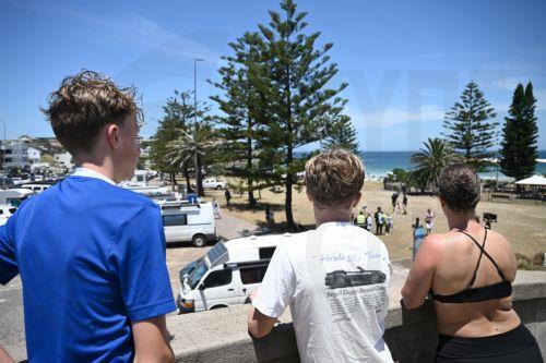 epa12599931 People look at Bondi Beach as the crime scene reopens to the public in Sydney, Australia, 18 December 2025. Australia is in mourning following an attack on the Jewish community's Hanukkah festival celebrations on 14 December in Bondi Beach, which left at least 16 people dead, including one gunman.  EPA/DAN HIMBRECHTS AUSTRALIA AND NEW ZEALAND OUT