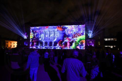epa12609230 People enjoy a light show projected on the building facade of the National Museum of Natural History of France during the 'Illuminating: Nature's lights' winter light festival at Jardin des Plantes in Paris, France, 22 December 2025. The 2025 edition, which runs from 12 November through 18 January 2026, showcases the lights emitted by nature on...