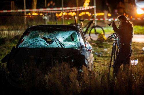 epa12609349 An investigator inspect a damaged car in a field at the scene of an accident on the Elburgerweg in Nunspeet, the Netherlands, 22 December 2025. According to police, a car drove into a group of people injuring at least nine people, including three with serious wounds.  EPA/ROLAND HEITINK