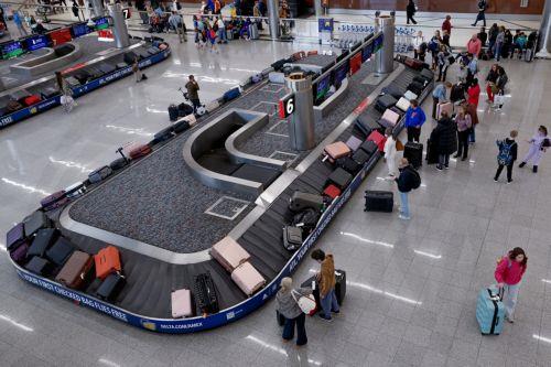 epa12609414 Air passengers collect their luggage while transiting through Hartsfield-Jackson Atlanta International Airport during the busy Christmas holiday travel season in Atlanta, Georgia, USA, 22 December 2025. Weather could cause delays for both air travelers and drivers.  EPA/ERIK S. LESSER