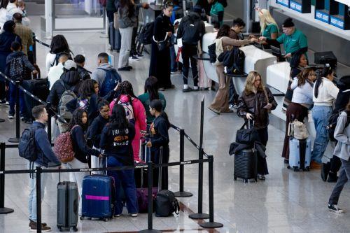 epa12609438 Air passengers check in for their flights while transiting through Hartsfield-Jackson Atlanta International Airport during the busy Christmas holiday travel season in Atlanta, Georgia, USA, 22 December 2025. Weather could cause delays for both air travelers and drivers.  EPA/ERIK S. LESSER