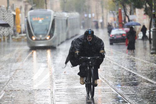 epa12616725 People walk in the rain during a stormy day in downtown Jerusalem, 29 December 2025. According to the Israel Meteorological Service, northern and central Israel, including Jerusalem, will experience occasional showers and isolated thunderstorms today, with strong westerly winds prevailing in most regions.  EPA/ABIR SULTAN