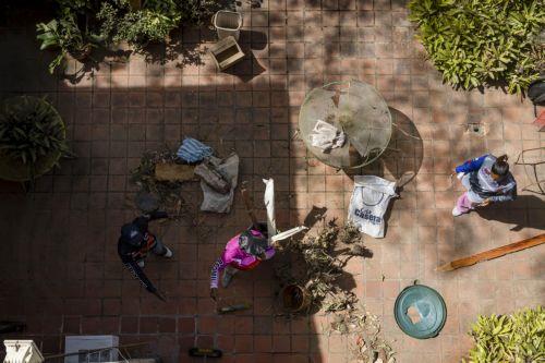 epa12632541 Government workers clean debris from a house damaged by the US attack in Caracas, Venezuela, 06 January 2026. Broken glass, bullet holes, dust, and paint remnants cover furniture and floors in several homes in a Caracas neighborhood affected by the US attack last 03 January, which culminated in the capture of President Nicolas Maduro and his...