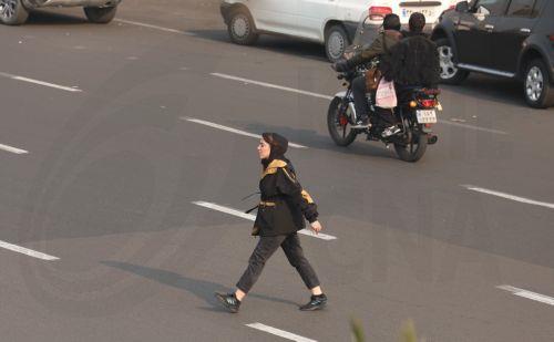 epa12635822 An Iranian crosses a street in Tehran, Iran, 08 January 2026. Following a sharp decline in the national currency and soaring prices for basic goods, the country is facing a wave of nationwide anti-government protests which has spread to 37 cities across 24 provinces, according to the Human Rights Activists News Agency (HRANA).  EPA/ABEDIN...