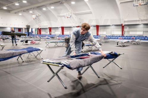 epa12636165 Employees and volunteers of De Regenboog Groep work at the Hogendorphal sports center which has temporarily been converted into a shelter for the homeles in Amsterdam, The Netherlands, 08 January 2026. Every spot in the standard shelters is occupied due to lot of snow and the chilly nights.  EPA/SIMON LENSKENS
