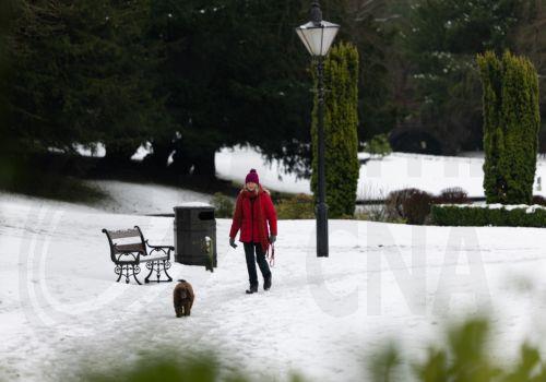 epa12637952 A person walks their dog through snow in the Pavilion Gardens in Buxton, Britain, 09 January 2026. Met Office yellow and amber warnings for ice, snow and wind remain in force across much of Britain after Storm Goretti, the first named storm of the year, brought heavy snowfall and strong winds.  EPA/ADAM VAUGHAN