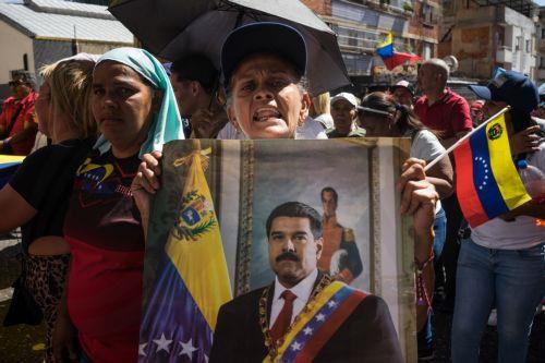 epa12639428 A person holds a poster with the image of Venezuelan President Nicolas Maduro during a demonstration in Caracas, Venezuela, 09 January 2026. Supporters Maduro called for his release after he and his wife, Cilia Flores, were captured by US forces during a military operation on 03 January 2026. Maduro and Flores are being held in the United States...