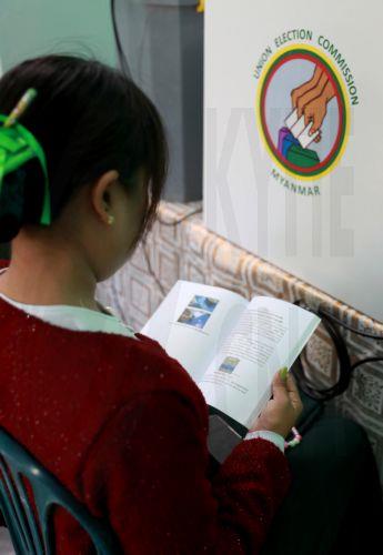 epa12639792 A volunteer of the Union Election Commission (UEC) reads a manual book of an electronic voting machine at a polling station, one day ahead of the second phase of election in Yangon, Myanmar, 10 January 2026. Myanmar's military government, known as the State Administration Council (SAC), plans to hold its first national vote since the February...
