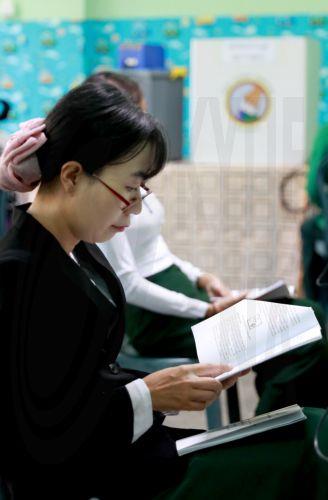 epa12639800 A volunteer of the Union Election Commission (UEC) reads a manual book of an electronic voting machine at a polling station, one day ahead of the second phase of election in Yangon, Myanmar, 10 January 2026. Myanmar's military government, known as the State Administration Council (SAC), plans to hold its first national vote since the February...