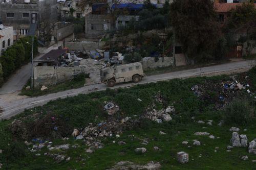 epa12644872 An Israeli army troop vehicle drives by during a military operation in Nur Shams refugee camp, near the West Bank city of Tulkarem, 12 January 2026. Israeli troops continue their operation in the Nur Shams refugee camp, east of Tulkarem, which has been under a tight Israeli siege since January 2025.  EPA/ALAA BADARNEH