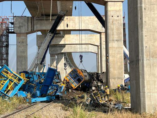 epa12648019 Workers walk on the site of the wreckage of a passenger train after a construction crane collapsed onto it in Sikhio district, Nakhon Ratchasima, Thailand, 14 January 2026. At least 22 people were killed and more than 79 others injured when the crane fell on the Special Express No. 21 train traveling from Bangkok to Ubon Ratchathani, according...