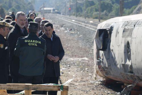 epa12664108 Spain's King Felipe VI (2-L), Queen Letizia (C, partially hidden), and Andalusian regional President Juanma Moreno (R) look at the damaged wagons of two of the trains involved in the crash between two high-speed trains that occurred on 18 January 2026, in Adamuz, Cordoba, Spain, on 20 January 2026. At least 41 people were killed after a...