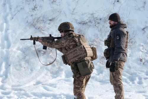 epa12675486 Infantry soldiers of the 13th Khartia Brigade of the National Guard of Ukraine take part in a military exercise at a training range in Kharkiv region, Ukraine, 23 January 2026. Extreme cold in Ukraine can lead to hypothermia for soldiers in trenches, affect how gunpowder performs, and slow reactions and dexterity, making training in these...