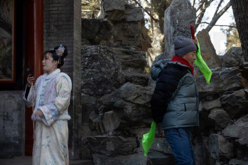epa12681815 A person practices dancing while another person takes a photo at a park in Beijing, China, 26 January 2026. In Beijing, tourists can purchase services such as traditional clothing rental, make-up application, hair up-dos, and photography to enhance their cultural experience of the city.  EPA/JESSICA LEE