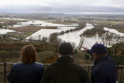 epa12719892 People look at overflowed Duero river passing through the town of Toro in Zamora, northwestern Spain, 09 February 2026. Heavy rainfall and storms caused floods in parts of Spain.  EPA/MARIAM A. MONTESINOS