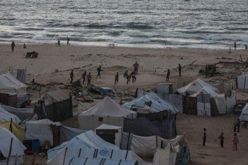epa12725553 Internally displaced Palestinians play football next to makeshift tents on the beach in Gaza City, Gaza Strip, 10 February 2026. A severe fuel shortage has forced residents to burn plastic waste as an alternative source of heat and energy, despite the toxic smoke it produces. The United Nations warns that the fuel crisis has reached an...