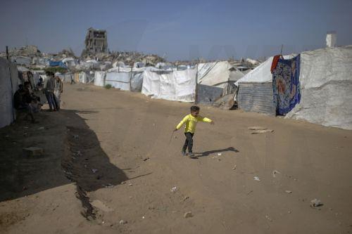 epa12731239 A displaced Palestinian boy plays near makeshift tents in the Al-Zaitun neighborhood of Gaza City, 12 February 2026, amid a ceasefire between Israel and Hamas. Despite an increase in humanitarian aid, the United Nations warned that the situation remains 'dire,' with children suffering from severe shortages of shelter, basic services, and...