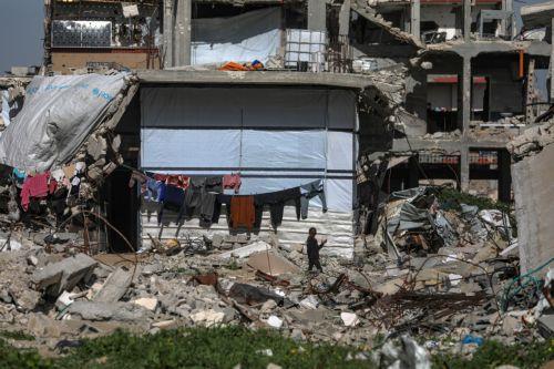 epa12731241 A displaced Palestinian girl walks next to her family makeshift tent among the ruins of the Al-Zaitun neighborhood of Gaza City, 12 February 2026, amid a ceasefire between Israel and Hamas. Despite an increase in humanitarian aid, the United Nations warned that the situation remains 'dire,' with children suffering from severe shortages of...