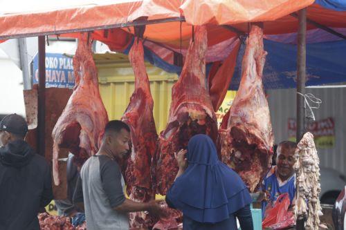 epa12745376 A vendor prepares meat at a flash market during the 'Meugang' meat festival held to welcome the month of Ramadan, in Banda Aceh, Indonesia, 16 February 2026. Meugang is know as a local tradition in Aceh to welcome a big holiday in Islamic calendar, such as Ramadan, Eid al Fith and Eid al-Adha, where people go to the market and buy more meat as a...