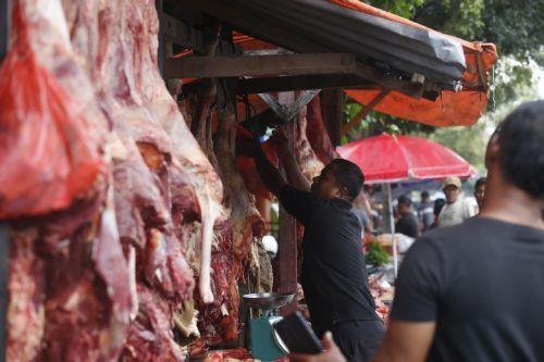 epa12745377 A vendor prepares meat at a flash market during the 'Meugang' meat festival held to welcome the month of Ramadan, in Banda Aceh, Indonesia, 16 February 2026. Meugang is know as a local tradition in Aceh to welcome a big holiday in Islamic calendar, such as Ramadan, Eid al Fith and Eid al-Adha, where people go to the market and buy more meat as a...