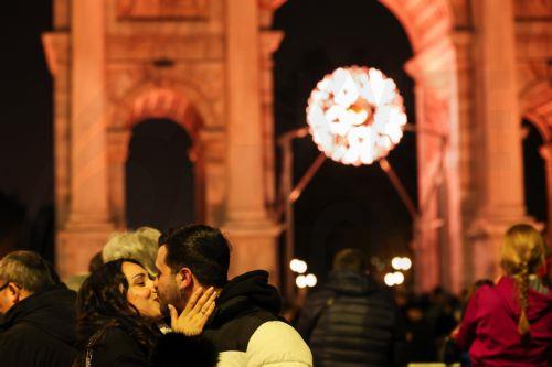 epaselect epa12770362 Two people kiss in front of the Olympic flame at the Arco della Pace in central Milan during the closing ceremony for the Milano Cortina 2026 Winter Olympic Games in Milan, Italy, 22 February 2026.  EPA/WU HAO