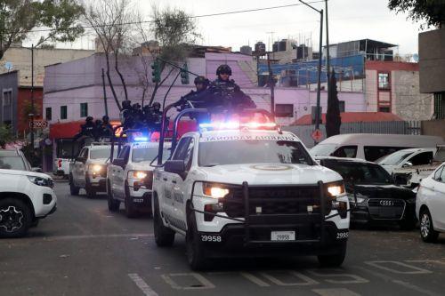 epa12770612 Members of the National Guard guard the area where the body of Nemesio Ruben Oseguera Cervantes, known as El Mencho, leader of the Jalisco New Generation Cartel, is taken after he is killed in Mexico City, Mexico, 22 February 2026. Mexico faces an escalation of violence, with fires and roadblocks reported in at least 16 of its 32 states,...