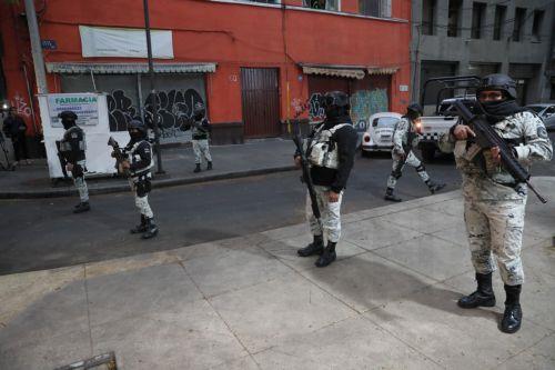epa12770615 Members of the National Guard guard the area where the body of Nemesio Ruben Oseguera Cervantes, known as El Mencho, leader of the Jalisco New Generation Cartel, is taken after he is killed in Mexico City, Mexico, 22 February 2026. Mexico faces an escalation of violence, with fires and roadblocks reported in at least 16 of its 32 states,...