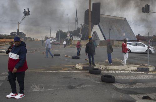 epa12772837 Police officers remove roadblocks from a blockaded street as residents from Coronationville and Westbury protest against the lack of water supply in many parts of Johannesburg, South Africa, 24 February 2026. The city is facing an increasingly dire water situation, with many areas already experiencing 'Zero Day' as their taps run dry. A...